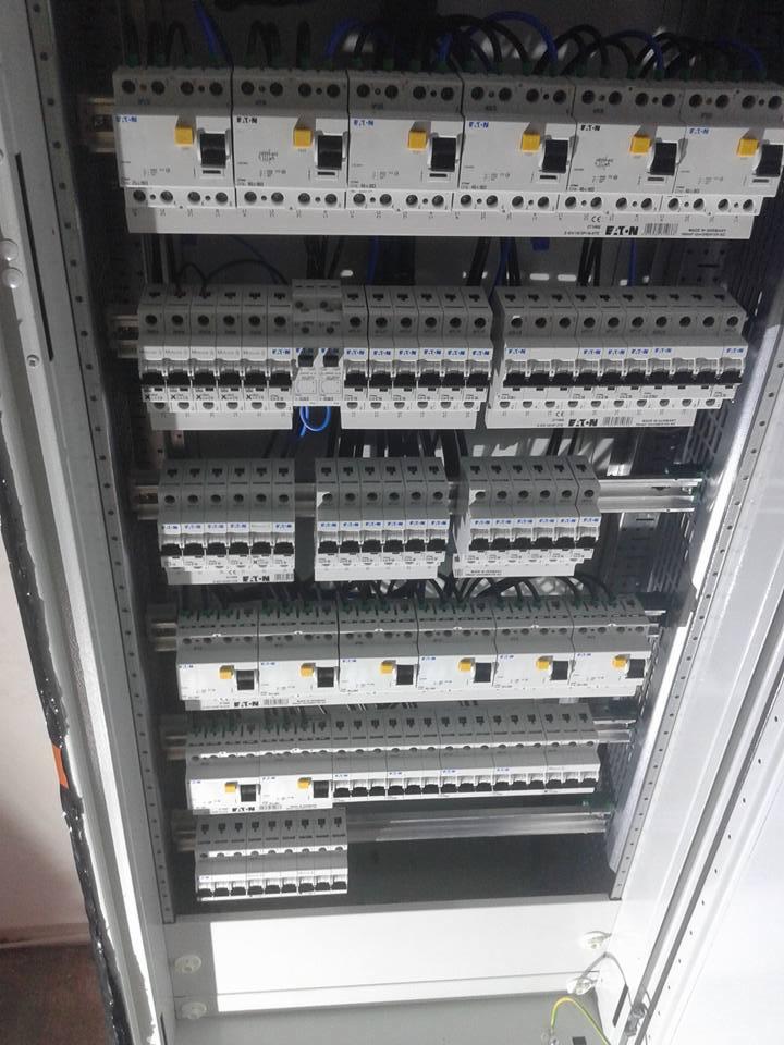 Rozdzielnica elektryczna z zamontowanymi bezpiecznikami firmy EATON, widok z góry, przewody elektryczne podłączone do poszczególnych zabezpieczeń.