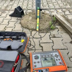 Energomontaż mgr inż. Zdzisław Adamczyk - Pomiar rezystancji uziemienia słupa za pomocą miernika Sonel MRU-200, widoczna torba z przewodami pomiarowymi. Testowanie instalacji odgromowej.