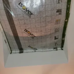 Montaż folii paroizolacyjnej Isover na suficie podwieszanym z płyt gipsowo-kartonowych, widok od dołu.