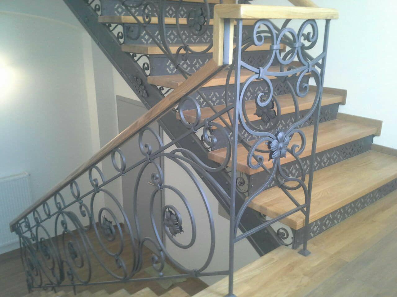 Kute balustrady schodowe z motywem roślinnym, drewniane stopnie schodów, jasne wnętrze.