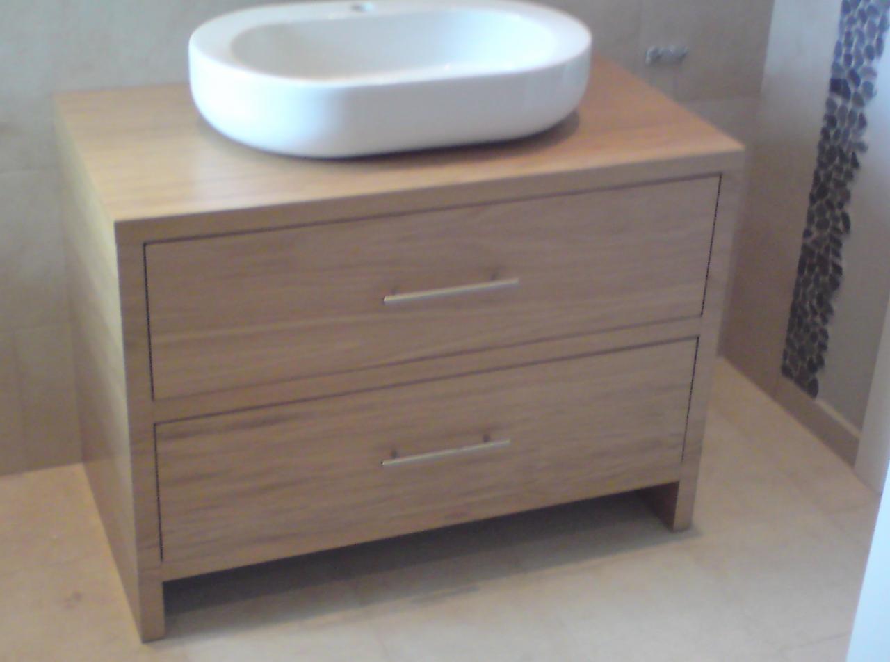 Drewniana szafka pod umywalkę z dwoma szufladami i owalną umywalką nablatową w łazience w Milanówku, widok z boku.