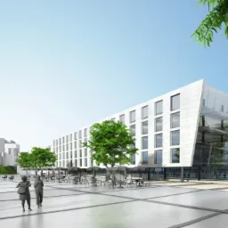 Wizualizacja budynku usługowego z nowoczesną elewacją i przeszklonym narożnikiem, na placu przed budynkiem widoczne stoliki, krzesła i spacerujący ludzie, w tle zabytkowa wieża.