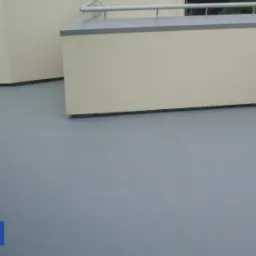 Szara, gładka hydroizolacja balkonu wykonana systemem Hydron, z widocznymi ścianami i metalową barierką.