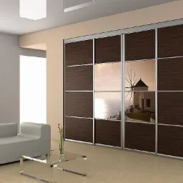 Nowoczesna szafa przesuwna z ciemnego drewna i lustrami, odbijającymi widok na morze i wiatrak, w minimalistycznym salonie z szarą sofą i szklanym stolikiem kawowym.