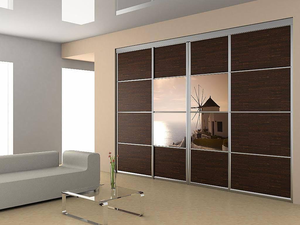 Nowoczesna szafa przesuwna z ciemnego drewna i lustrami, odbijającymi widok na morze i wiatrak, w minimalistycznym salonie z szarą sofą i szklanym stolikiem kawowym.