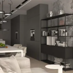 Nowoczesne wnętrze: szare szafki kuchenne z wbudowanym ekspresem do kawy, stół z owocami, metalowy regał z książkami na tle betonowej ściany z efektem dekoracyjnym.