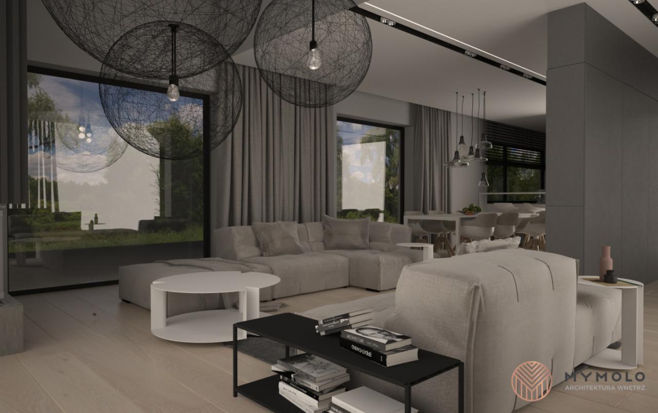 Wizualizacja przestronnego wnętrza w Tarnobrzegu z szarymi zasłonami, sofą modułową, okrągłym stolikiem kawowym i oryginalnymi lampami wiszącymi w kształcie kuli z cienkich drutów, widok na ogród...