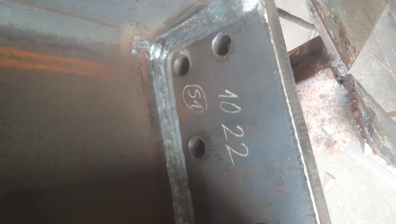 Spoina narożna łącząca dwie stalowe płyty, z widocznymi otworami i napisem '10 22 (51)' naniesionym markerem na jednej z płyt.