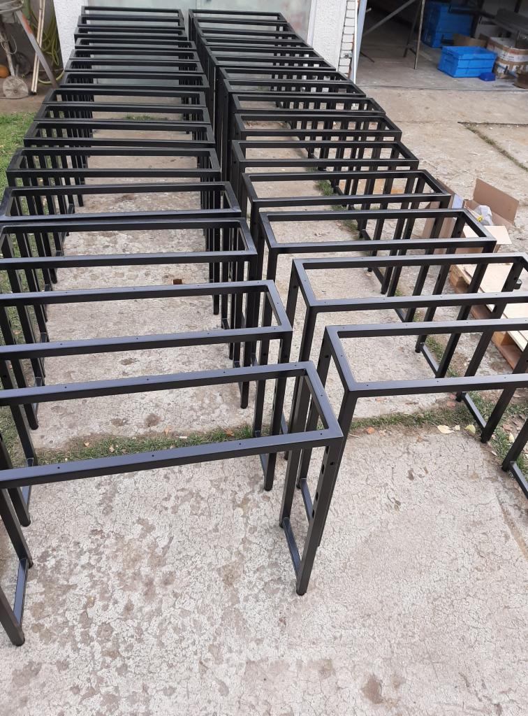 Metalowe ramy stołów, przygotowane w Trojanowie, ustawione w rzędach na zewnątrz, czekające na dalszą obróbkę lub transport.