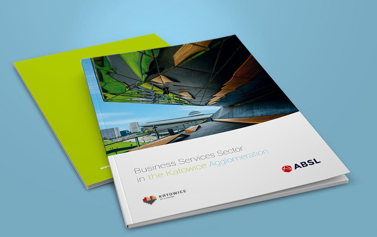 Dwa katalogi, jeden otwarty z widokiem na Spodek w Katowicach i tekstem 'Business Services Sector in the Katowice Agglomeration', drugi zamknięty w kolorze limonkowym, na jasnoniebieskim tle.