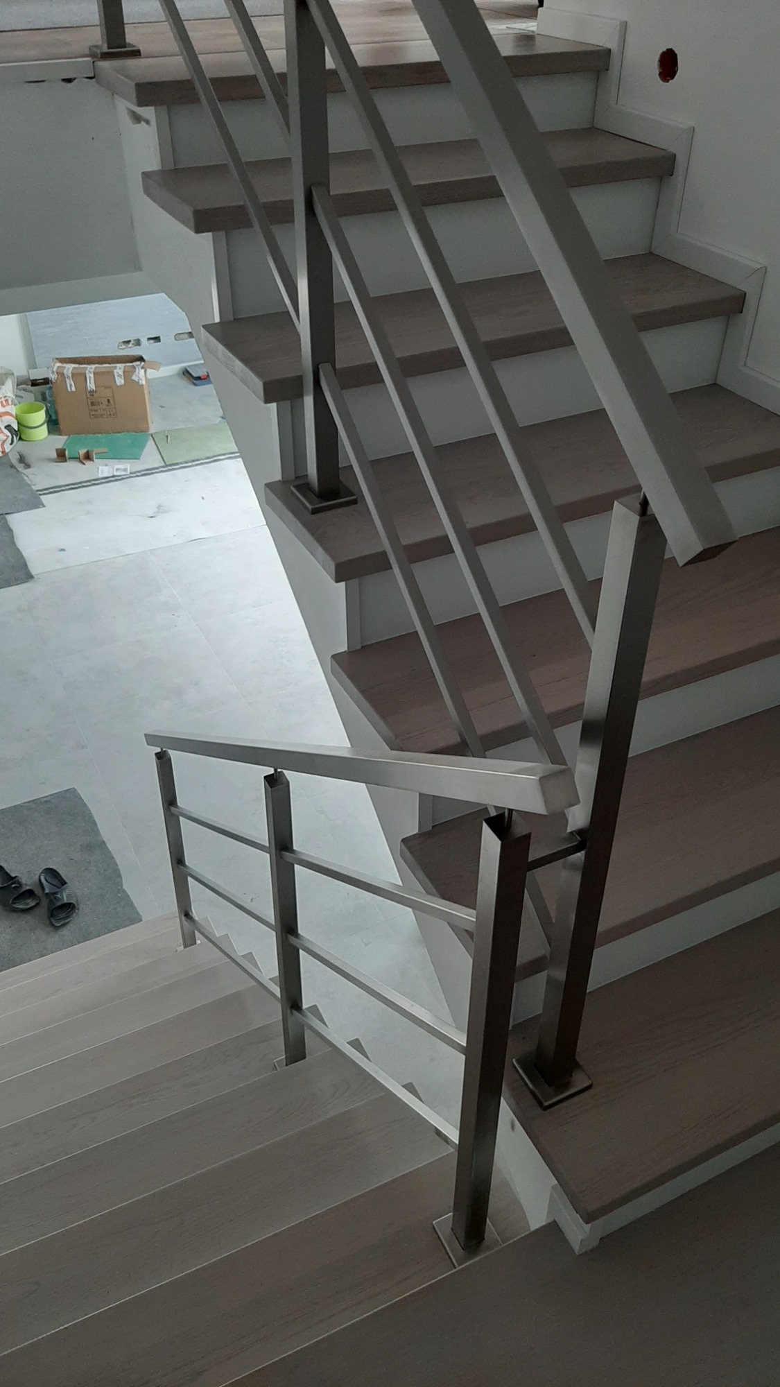 Schody z drewnianymi stopniami i nowoczesną balustradą nierdzewną z kwadratowych profili, widok z góry, realizacja w Zbiersku-Cukrowni.