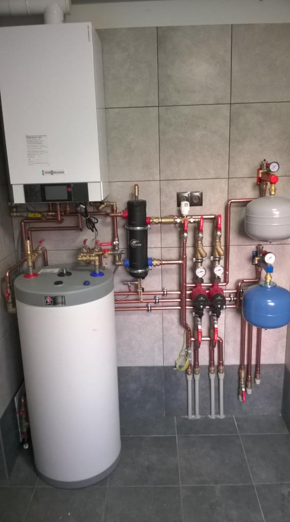 Złożona instalacja centralnego ogrzewania z piecem gazowym Viessmann, zbiornikiem buforowym i filtrem magnetycznym, wykonana w kotłowni w Sieciechowie. Widoczne miedziane rury, manometry i zawory.