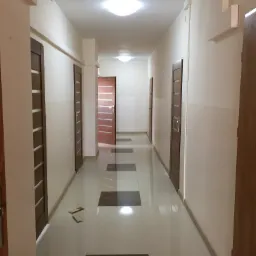 Korytarz po odświeżeniu w Pińczowie z nowymi drzwiami i błyszczącą podłogą z ciemnymi wstawkami, widoczne listwy przypodłogowe i narzędzia na podłodze.