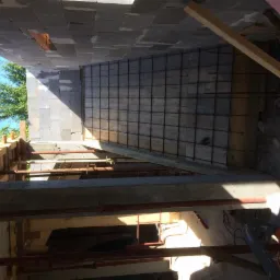 Siatka zbrojeniowa przygotowana pod ocieplenie ściany w Alwerni, widok z góry na konstrukcję szalunkową i elementy drewniane.