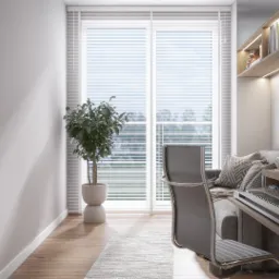 Jasne, nowoczesne biuro domowe z biurkiem, syntezatorem klawiszowym, wygodną sofą z poduszkami, półkami z książkami i rośliną doniczkową przy oknie.