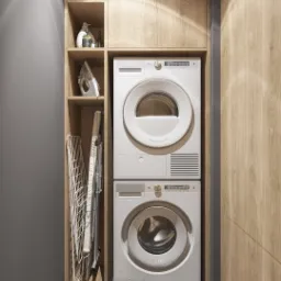Pralka i suszarka w zabudowie z drewnianymi szafkami w łazience, obok półka z żelazkiem i środkami czystości, rozkładana suszarka na pranie oraz kosz z praniem.