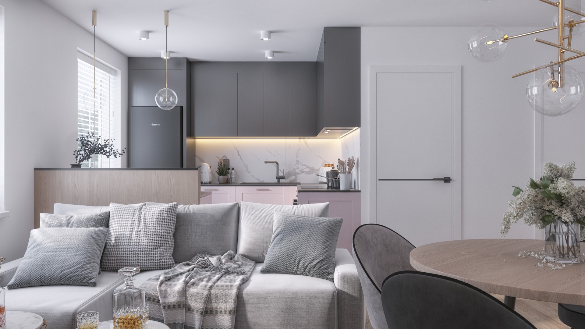 Nowoczesne wnętrze mieszkania: szara kuchnia z różowymi szafkami dolnymi, marmurowy backsplash, oddzielona od salonu barkiem, szara sofa z dekoracyjnymi poduszkami i szklana karafka na stoliku...