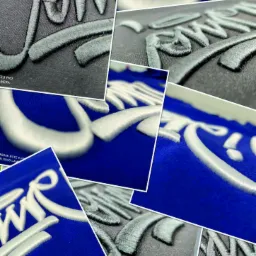 Kompozycja zbliżeń na tekstylia z trójwymiarowym haftem, prezentująca detale szwów i tekstur na czarnym i niebieskim materiale.