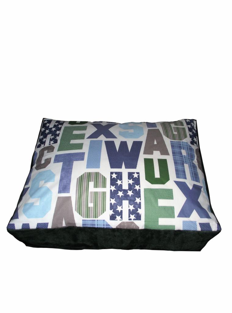 Kwadratowa poduszka dekoracyjna z wzorem liter w odcieniach zieleni, niebieskiego i szarości na białym tle, wykończona ciemnozielonym welurem.