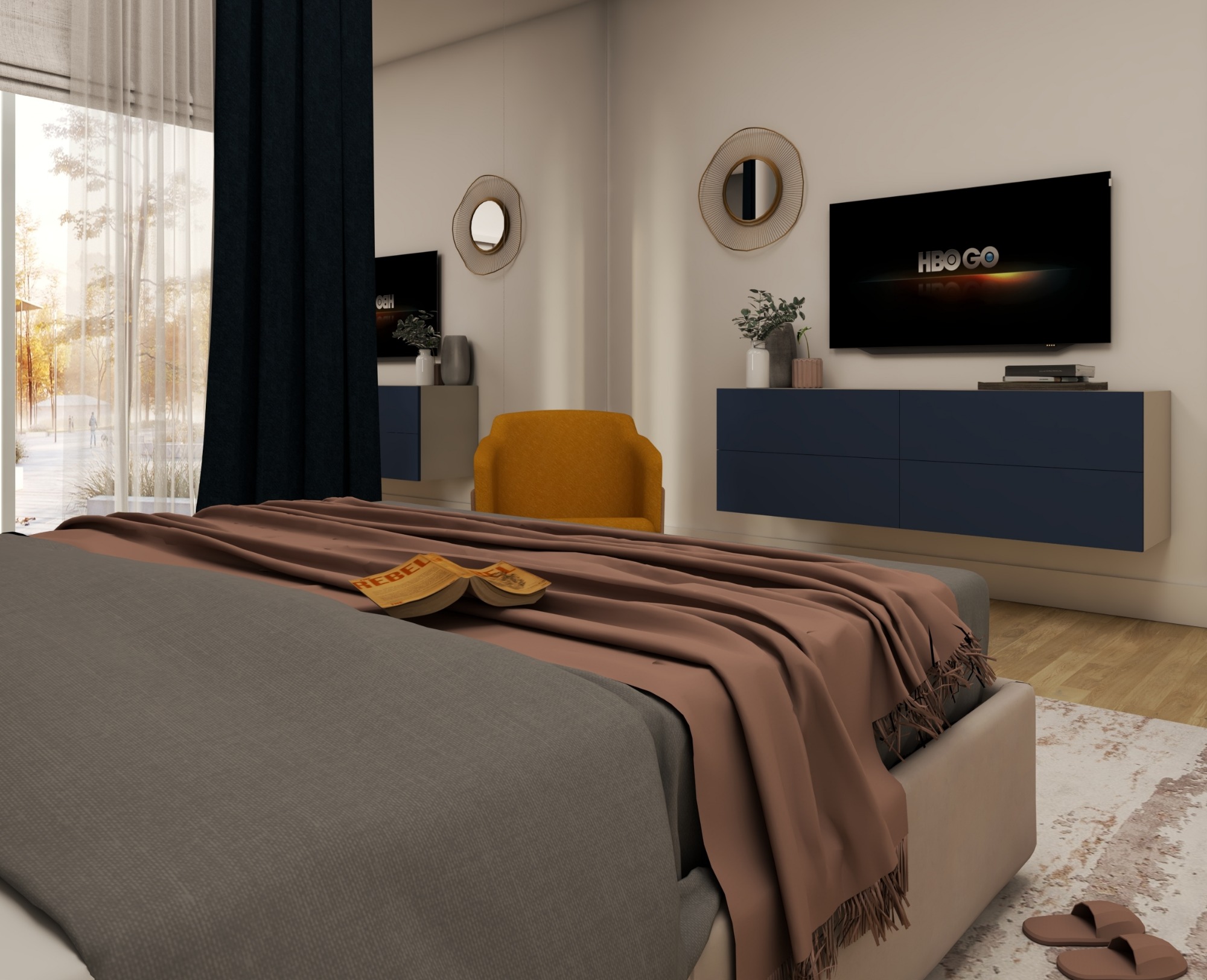 Sypialnia w neutralnych barwach z łóżkiem z szarą pościelą i brązowym pledem, na którym leży otwarta książka 'Rebel'. W tle żółty fotel, szafki w kolorze granatowym z roślinami i telewizor z logo...