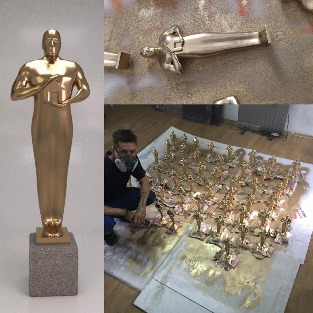 Malowanie natryskowe złotych statuetek: pracownik w masce ochronnej, statuetki na podkładzie malarskim, detale statuetek w trakcie malowania.