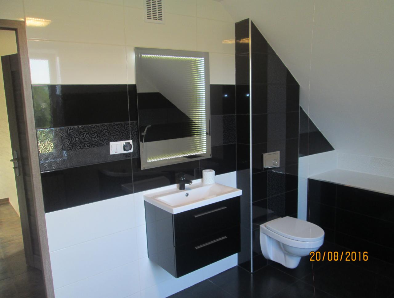 Nowoczesna łazienka w czarno-białej kolorystyce z podświetlanym lustrem infinity, wiszącą toaletą i umywalką z szafką, wykończona płytkami ceramicznymi z datą ukończenia widoczną w prawym dolnym rogu.