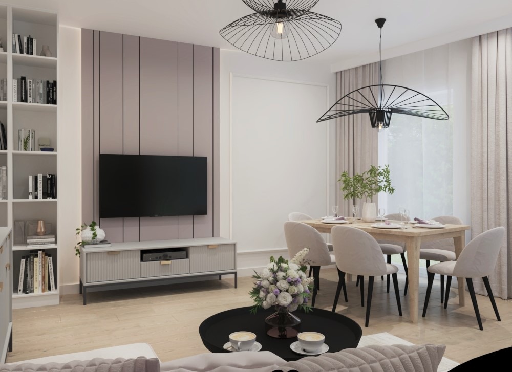 Jasne wnętrze z telewizorem na ścianie, stołem jadalnym z krzesłami i okrągłym stolikiem kawowym z filiżankami, oświetlone wiszącymi lampami o ażurowych kloszach.