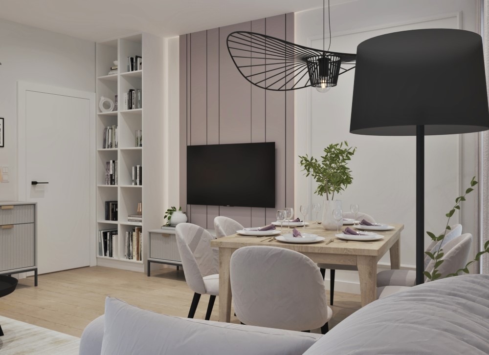 Jasne wnętrze jadalni z drewnianym stołem, białymi krzesłami, dekoracyjną lampą wiszącą i regałem z książkami w tle. Na stole nakrycia z fioletowymi akcentami.