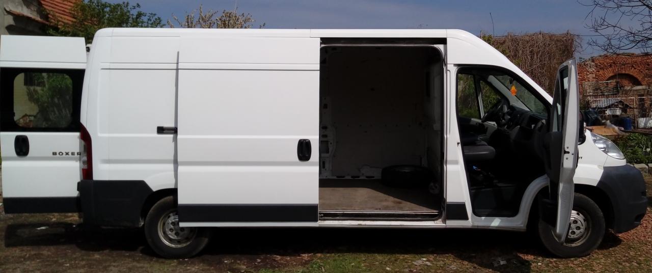 Biały bus marki Boxer z otwartymi drzwiami bocznymi i tylnymi, ukazujący pustą przestrzeń ładunkową.