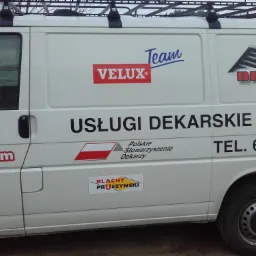 Biały samochód dostawczy z reklamą firmy dekarskiej, widoczne logo Velux, Dekpol, Blachy Pruszyński, numer telefonu i adres strony internetowej.