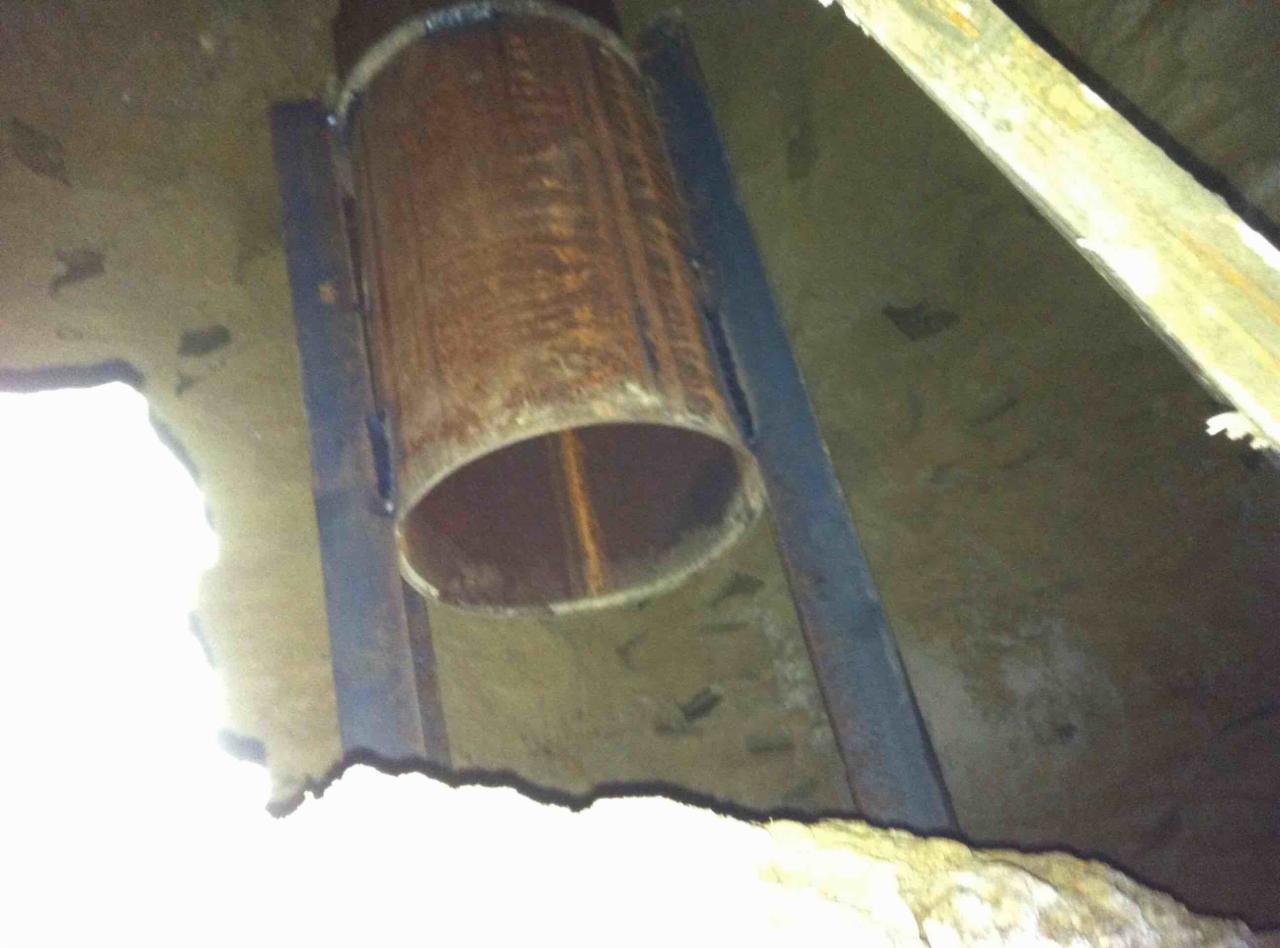 Metalowa rura w ziemi, podtrzymywana przez metalowe belki, prawdopodobnie element szalunku traconego pod przyszły słup fundamentowy.