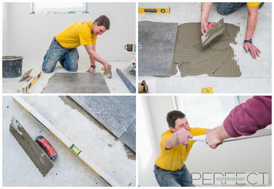 Montaż płytek podłogowych: glazurnik nakłada klej na podłogę, widoczne poziomice, szpachelki i wiadro z zaprawą, w tle jasne ściany i okno.