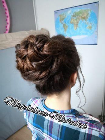 Upięcie włosów w formie warkocza i koka, widok z tyłu, na ścianie mapa świata, bluzka w kratę.