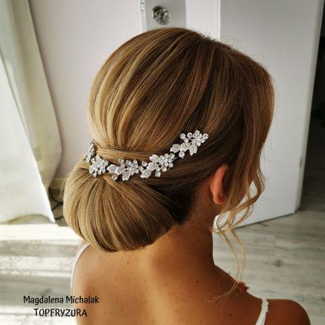 Upięcie włosów z ozdobną, srebrną spinką w kształcie kwiatów, widok z tyłu, jasne włosy.