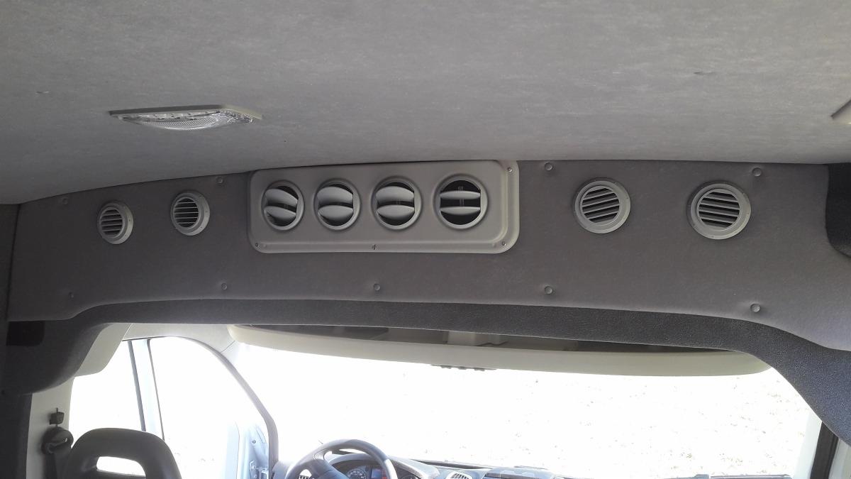 Wnętrze samochodu dostawczego z widocznymi nawiewami klimatyzacji w podsufitce, skierowanymi do pasażerów.