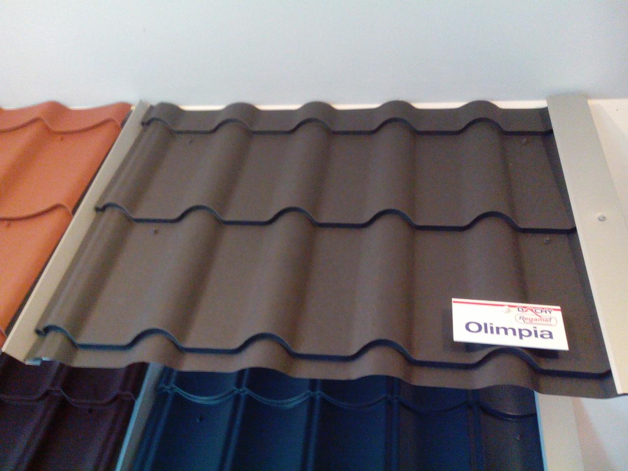 Ekspozycja próbek pokrycia dachowego z blachy trapezowej w odcieniach brązu, z widoczną etykietą 'Olimpia'.