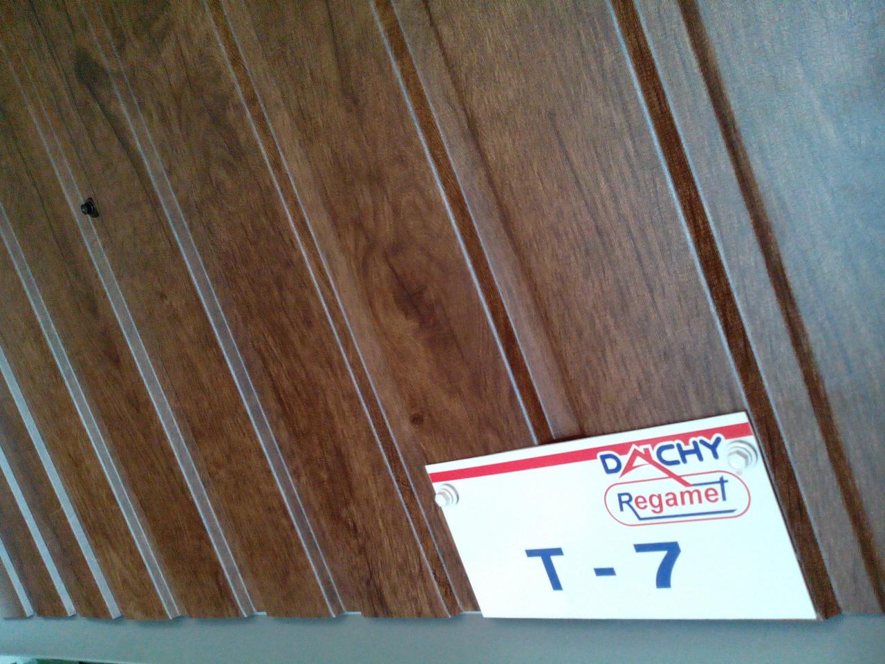 Próbka paneli dachowych Regamet T-7 o strukturze drewna, widoczny detal mocowania.