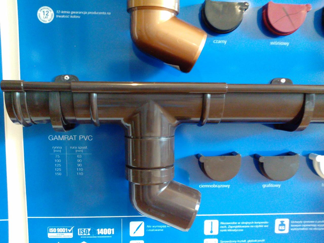 Brązowy system rynnowy Gamrat PVC, prezentacja z różnymi kolorami i wymiarami, widoczne certyfikaty ISO 9001 i ISO 14001.
