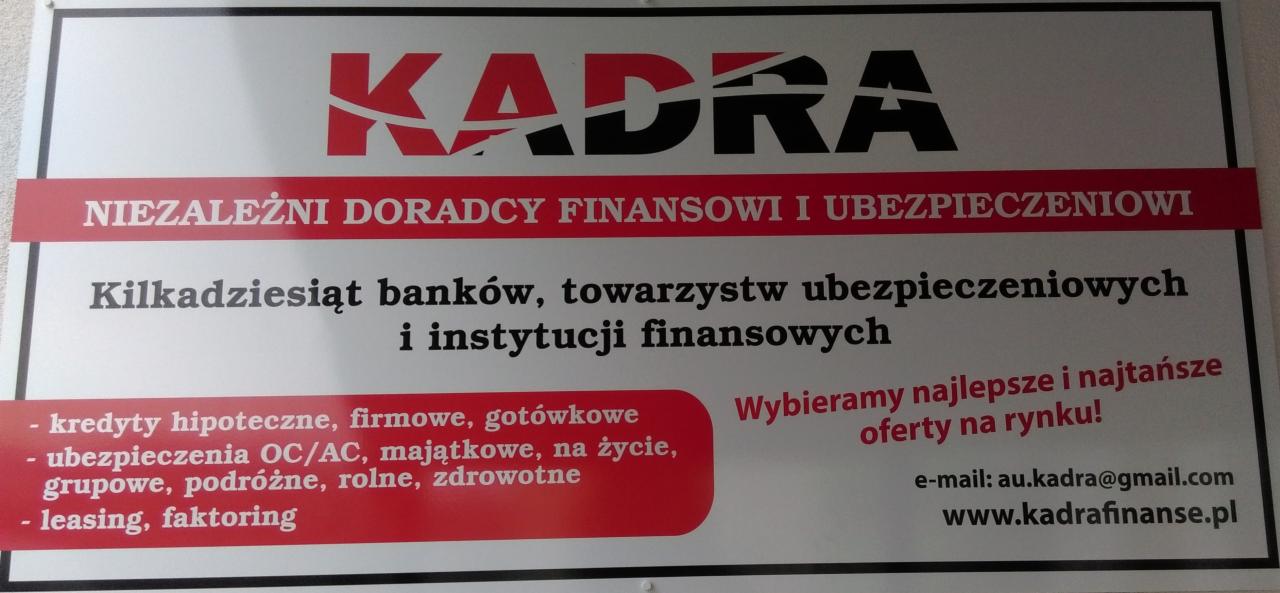 Tablica informacyjna z logo 'KADRA', oferująca usługi finansowe i ubezpieczeniowe, w tym kredyty, ubezpieczenia i leasing, z adresem e-mail i stroną internetową.