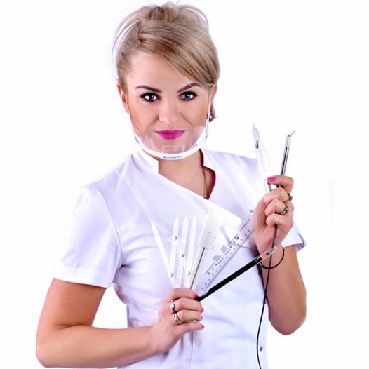 Kosmetolog w białym uniformie i przezroczystej masce ochronnej, trzymająca w dłoniach zestaw narzędzi do makijażu permanentnego brwi i linijkę do pomiaru.