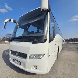 Erfil Trans Wynajem Autokarów, Przewozy Autokarowe, Wynajem Busa, Piaseczno, Warszawa - Biały autokar turystyczny Volvo z numerem rejestracyjnym WPI 7666L, zaparkowany na betonowym placu w słoneczny dzień. Widok z boku, lekko od dołu.