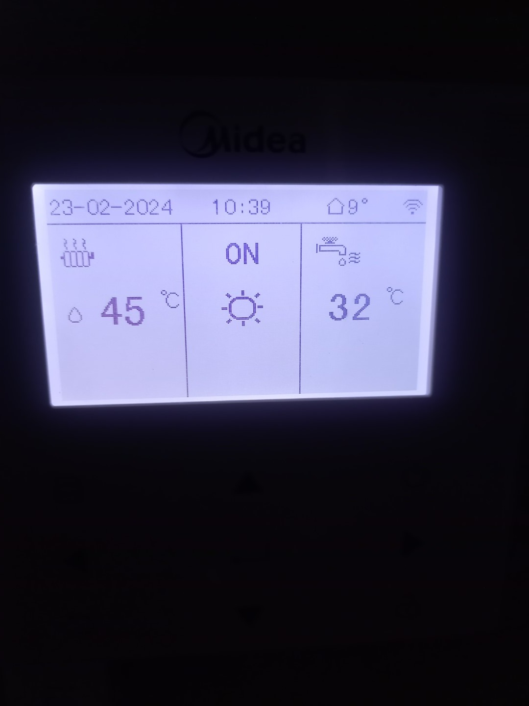Ekran sterownika Midea z wyświetlanymi temperaturami ogrzewania (45°C) i ciepłej wody użytkowej (32°C), datą 23-02-2024 i informacją o włączonym ogrzewaniu.