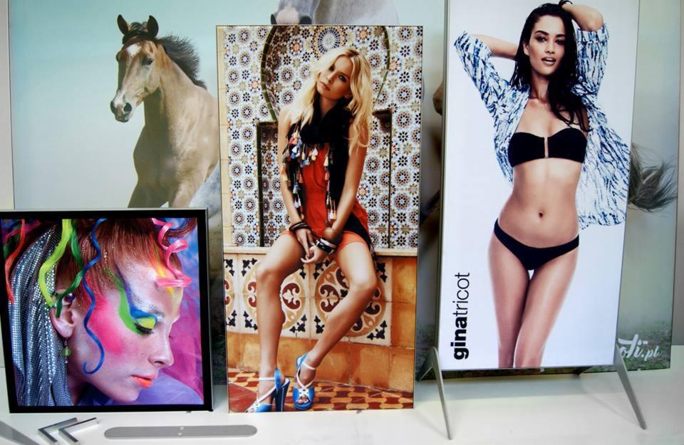 Prezentacja wydruków na sztywnych podłożach: portret konia, modelka w stroju kąpielowym marki ginatricot, kobieta w sukience na tle mozaiki, portret kobiety z fantazyjnym makijażem.