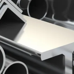 Błyszczące, metalowe rury o okrągłym przekroju oraz profile o przekroju kwadratowym i kątowniki ułożone w stos, z efektem głębi ostrości.