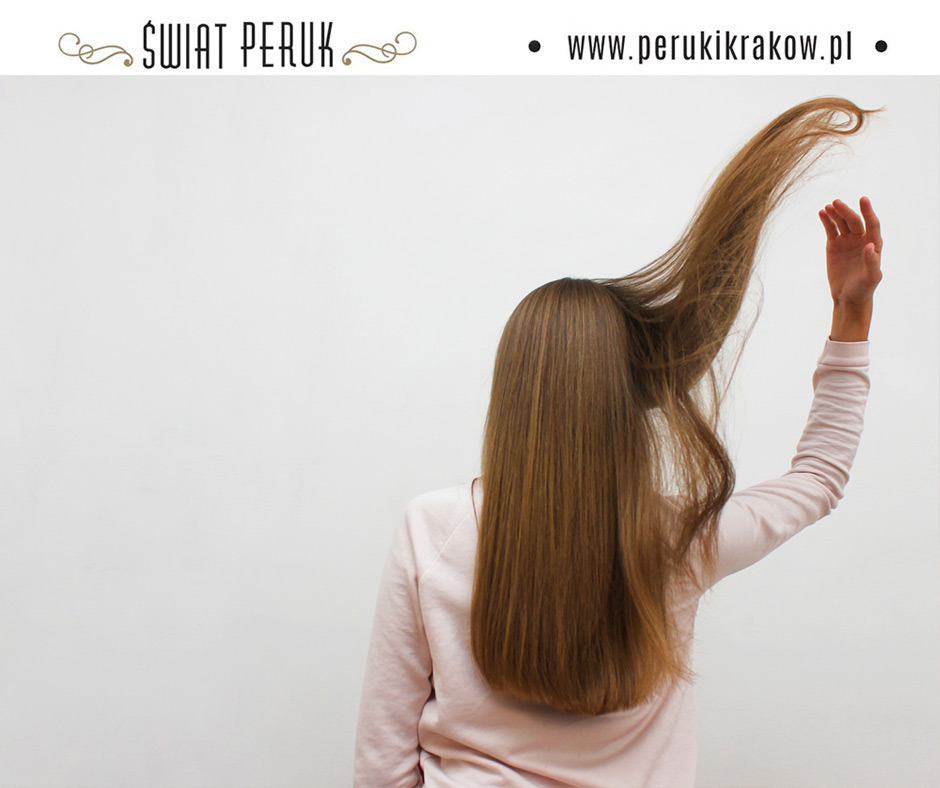 Prezentacja peruki w Krakowie: kobieta tyłem, uniesiona dłoń modeluje długie, proste, brązowe włosy, widoczne logo firmy 'Świat Peruk' i adres strony internetowej.