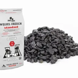Worek węgla orzech standard 25 kg, obok pryzma czarnego węgla na białym tle.