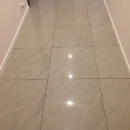 Ułożona podłoga z płytek ceramicznych imitujących marmur w korytarzu, widok z góry, fuga w kolorze szarym.