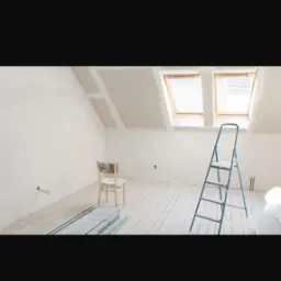 Pokój na poddaszu w trakcie wykańczania: białe ściany, drewniana podłoga, okna dachowe, drabina i krzesło. Widoczne profile do zabudowy.
