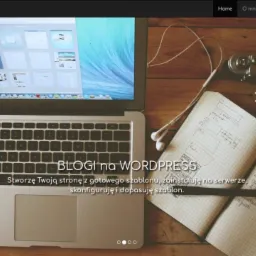 Laptop z otwartą pokrywą, wyświetlający interfejs strony internetowej, leżący na drewnianym biurku obok notatnika z odręcznymi szkicami i notatkami, słuchawek oraz starego aparatu fotograficznego.