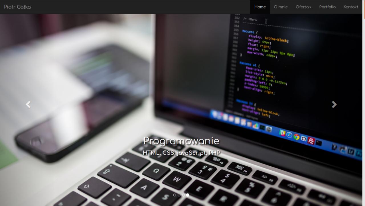 Laptop z wyświetlonym kodem HTML/CSS/JavaScript, smartfon i notatki na biurku, widok z góry na klawiaturę laptopa.